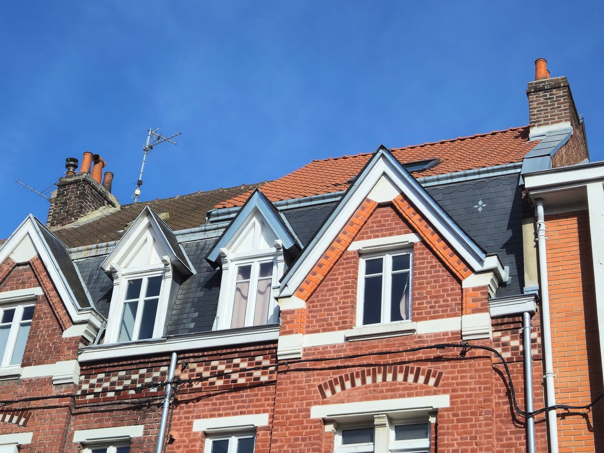Maisons mitoyennes en brique avec toitures en tuiles et en ardoise